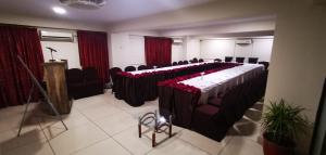 卡拉奇皇冠假日酒店的一间会议室,里面设有一张长桌子,上面有红玫瑰