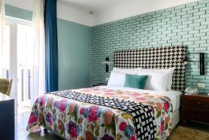 特拉维夫中心别致酒店 - 阿特拉斯精品酒店的一间卧室设有一张床和砖墙