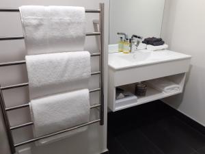 凯里凯里凯里凯里家园汽车旅馆公寓的浴室配有白色水槽和毛巾
