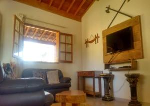 圣托梅-达斯莱特拉斯Chalé Boa Vista的带沙发和电视的客厅
