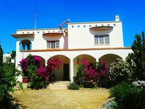 托雷桑塔萨宾娜B&B Santa Sabina的前面有粉红色花的白色房子