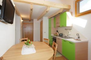普雷达佐Casa Seler - Appartamento verde的厨房以及带木桌的用餐室。