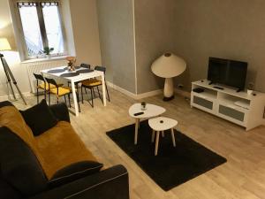 盖雷Appartement Guéret的客厅配有沙发、桌子和电视