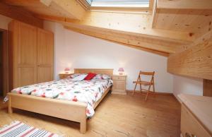 普雷达佐Casa Seler - Appartamento rosso的一间带一张床的卧室,位于带木制天花板的房间内