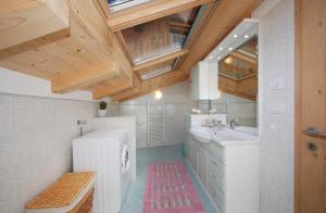 普雷达佐Casa Seler - Appartamento rosso的一间带白色水槽和木制天花板的浴室