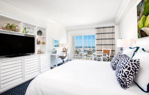 基韦斯特基韦斯特海洋边缘度假村的白色卧室设有一张大床和一台平面电视。