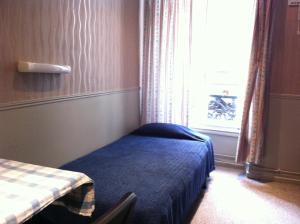 巴黎艺术酒店的小房间设有床和窗户