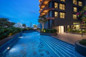 新加坡Citadines Rochor的一座游泳池,在晚上在建筑物前