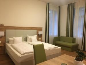 海德堡Perkeo Apartments的一间卧室配有一张床和一把绿色椅子