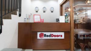 巴科洛德RedDoorz Plus @ Diola Villamonte Bacolod的墙上挂着时钟的餐厅里的一个红色门标