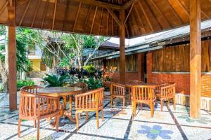 玛琅RedDoorz Syariah near Gor Ken Arok的户外庭院配有木桌和椅子