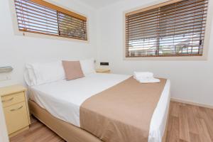 科夫斯港BIG4公园海滩假日公园的一间卧室设有一张大床和两个窗户。