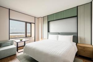 哈尔滨哈尔滨香格里拉的卧室配有一张白色的大床和一张沙发。