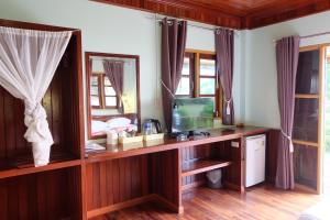 Ko Sukon亚塔阿SPA度假酒店的一间卧室,配有木桌上的电视