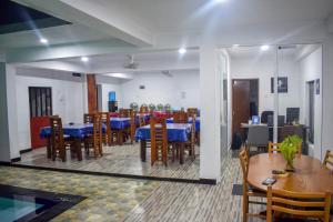 波隆纳鲁沃Lion Resort的用餐室配有蓝色桌子和木椅