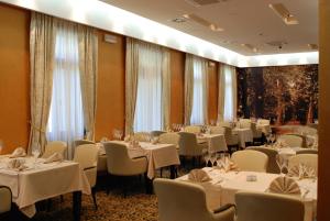 萨拉热窝赫塞哥维纳酒店的一间设有白色桌椅的用餐室
