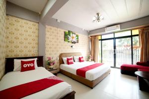大城OYO 465 Krung Kao Traveller Lodge的酒店客房设有两张床和一个阳台。