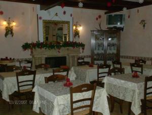 佩斯卡塞罗利Albergo Andromeda的一间设有白色桌子和壁炉的用餐室