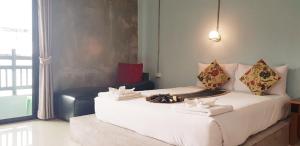 甲米镇The Guest Hotel Krabi的卧室配有一张白色大床和椅子