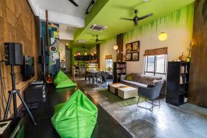 吉隆坡吉隆坡POD背包客咖啡馆旅舍的客厅设有绿色的墙壁和沙发