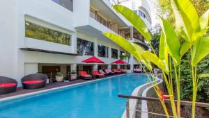 努沙杜瓦Nunamkhalu Private Villa and Spa的酒店游泳池旁设有红色椅子