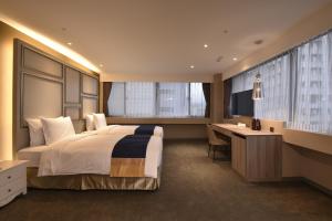 台北洛碁大饭店忠孝馆的酒店客房设有一张大床和一张书桌。