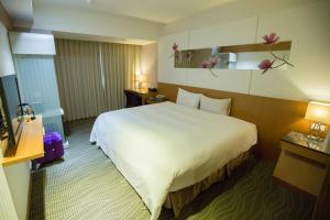台北Hotel Zoo的一间酒店客房,配有一张白色大床