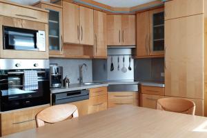 马耳他Ferienwohnung Strasser的厨房配有木制橱柜和桌椅