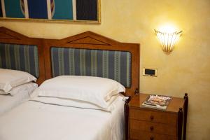 罗马贝斯特韦斯特艺术装饰酒店的一间卧室配有一张床和一个带床罩的床头柜。