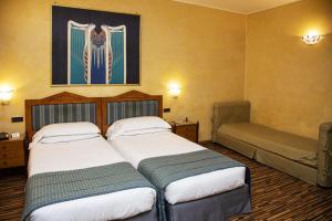 罗马贝斯特韦斯特艺术装饰酒店的酒店客房设有两张床,墙上挂有绘画作品