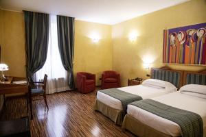 罗马贝斯特韦斯特艺术装饰酒店的酒店客房配有两张床和一张书桌