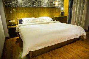 南宁胜华文创公寓的卧室配有一张带白色床单和枕头的大床。