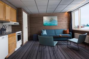朗伊尔城Svalbard Hotell | Lodge的客厅配有沙发和桌椅