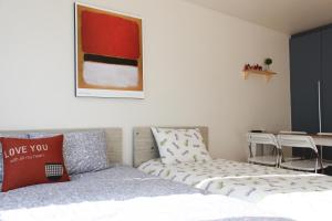 首尔弘大萨姆旅舍的一间卧室配有一张床和一张桌子及椅子
