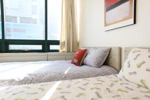 首尔弘大萨姆旅舍的一间卧室配有一张带枕头和窗户的床