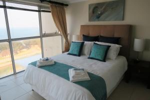 莫塞尔湾Sea-View Nautica @ Mossel Bay的一间卧室配有一张大床和毛巾