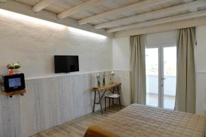 莫诺波利马赛利亚圣塔特雷莎酒店的一间卧室配有一张床,墙上配有电视