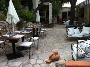 滨海拉塞讷法布雷加斯住宿加早餐旅馆的庭院配有桌椅和一张桌子及雕像