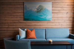 朗伊尔城Svalbard Hotell | Lodge的客厅配有蓝色的沙发和北极熊游泳