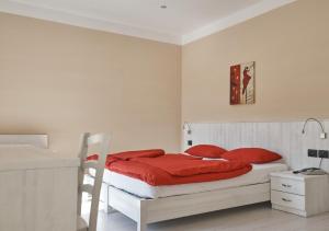 拉瓦罗内Hotel du Lac Parc & Residence的白色卧室配有红色枕头的床