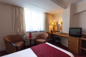 伯恩茅斯大不列颠圆屋酒店的酒店客房配有一张床、一张书桌和一台电视。