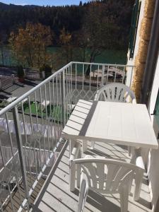 拉瓦罗内Hotel du Lac Parc & Residence的阳台上配有一张白色野餐桌和两把椅子