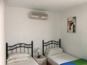 波多黎各Bungalow Isla Margarita的一间卧室配有两张床和空调。