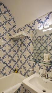 索伦托亚敏塔大酒店的浴室拥有蓝色和白色的瓷砖墙壁和水槽