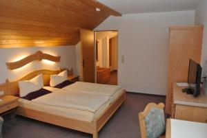 因斯布鲁克Hotel Gruberhof Innsbruck Igls B&B的一间卧室配有一张大床和电视