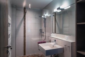 埃圭斯海姆B&B Relais du Vigneron - Jean-Luc et Bruno Meyer的白色的浴室设有水槽和淋浴。