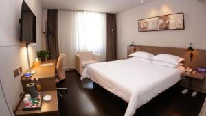 银川锦江之星品尚银川清和南街酒店的酒店客房配有一张床、一张书桌和一台电视。