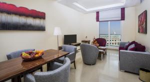 迪拜The View Al Barsha Hotel Apartments的用餐室配有椅子和一张带一碗水果的桌子