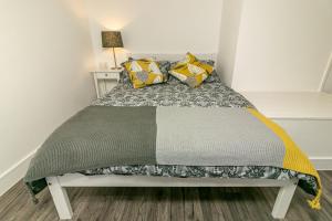 莱奇沃思Denby Lodge的一间小卧室,配有一张带黄色枕头的床