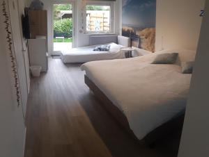 德科赫Duin en Zee Texel的一间卧室设有两张床和窗户。